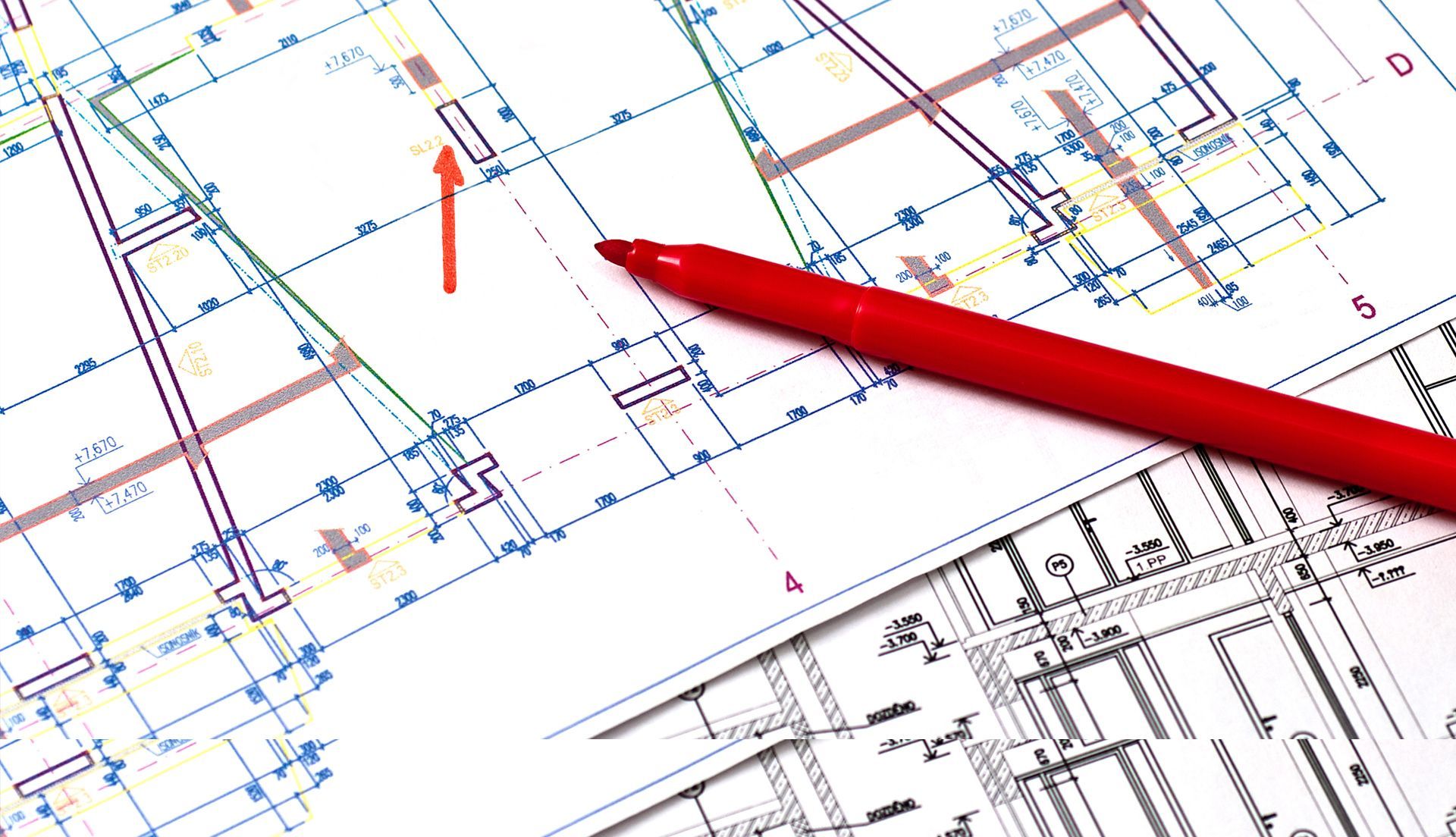 A red pen resting on a blueprint, representing architectural design