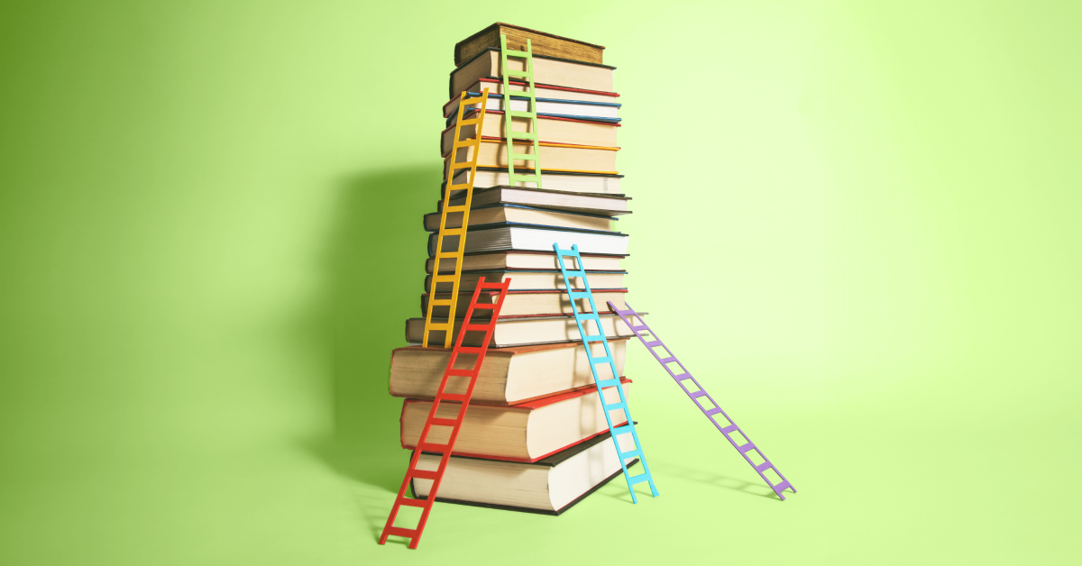 A stack of books with different color ladders leaned against it on a green background. 