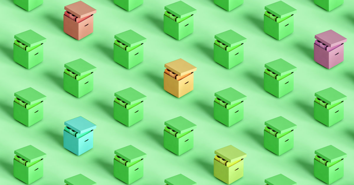 Different color packed up office boxes on a green background. 