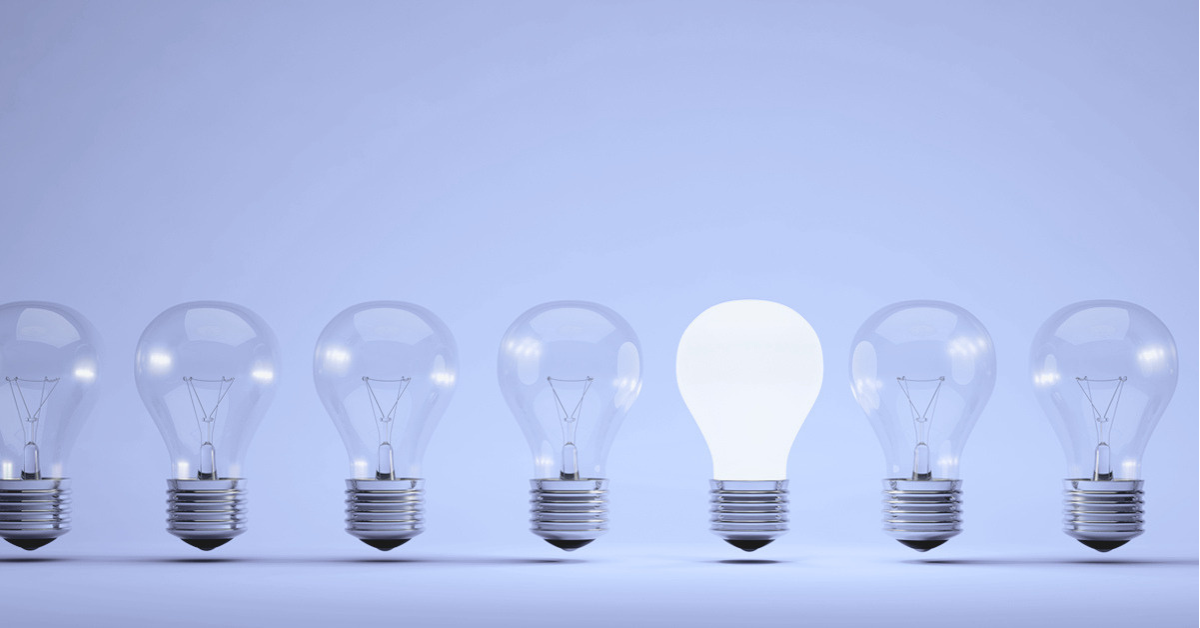 Row of light bulbs, one illuminating, representing ideas and innovation