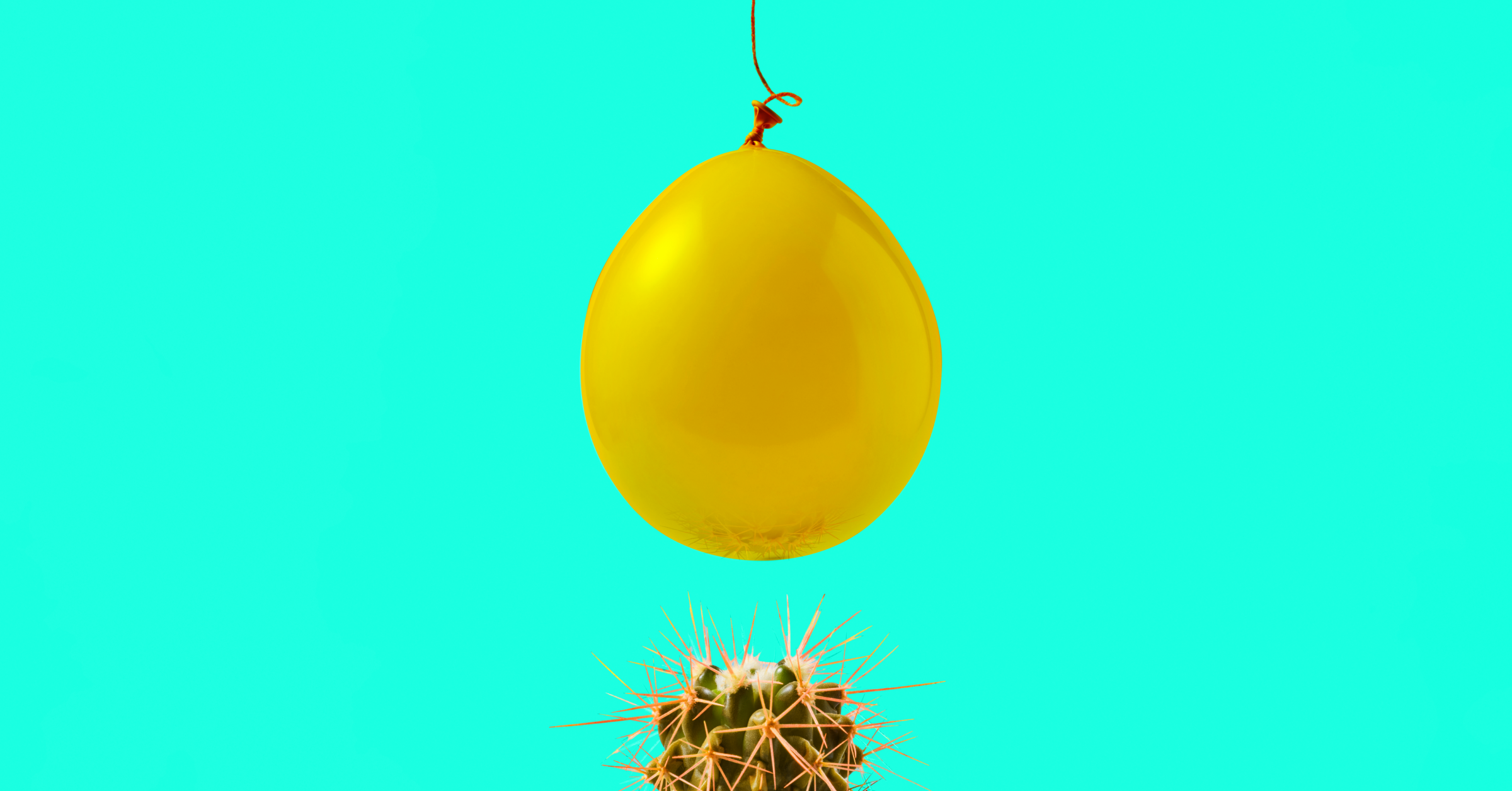 A yellow balloon hanging over a cactus on a blue background. 