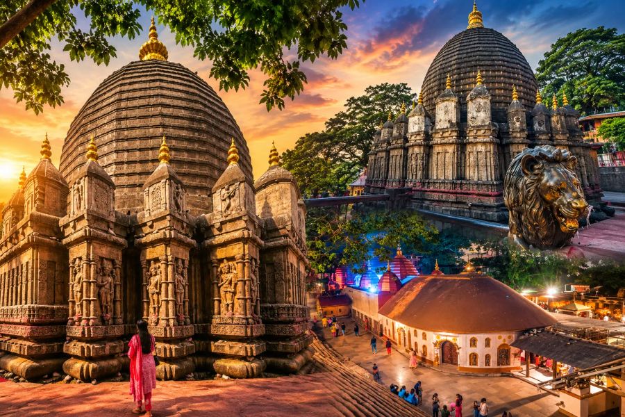 Kamakhya Temple Guwahati, Assam, featuring its historic stone architecture, domes, temple complex, lion sculpture, and surrounding greenery