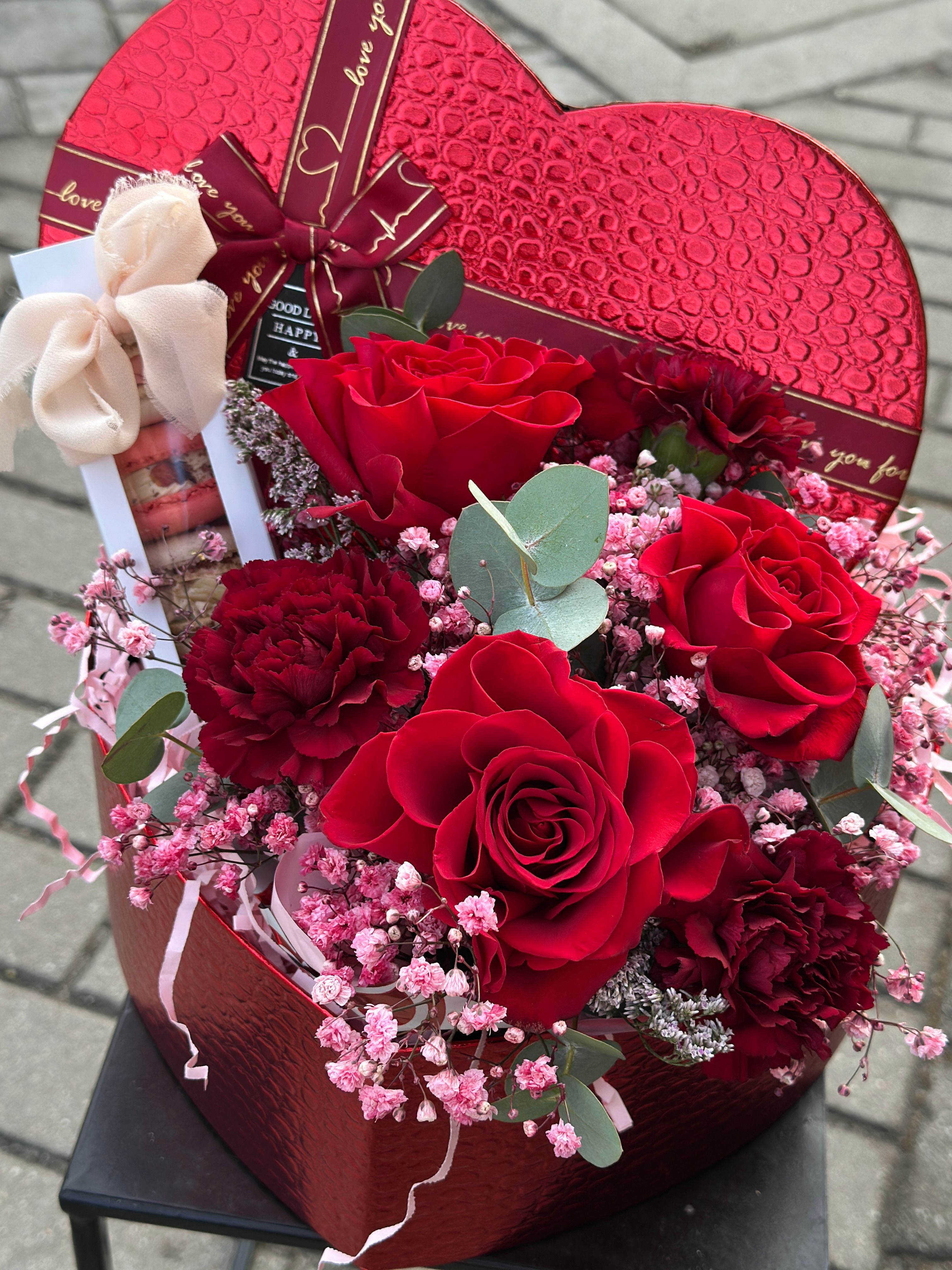 Flowerbox w kształcie SERCA w odcieniach różu i bordo, z delikatną różową gipsówką oraz starannie dobranymi kwiatowymi dodatkami.