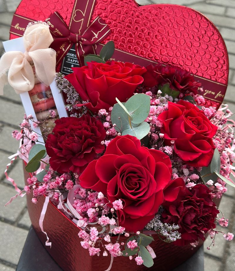 Flowerbox w kształcie SERCA w odcieniach różu i bordo, z delikatną różową gipsówką oraz starannie dobranymi kwiatowymi dodatkami.