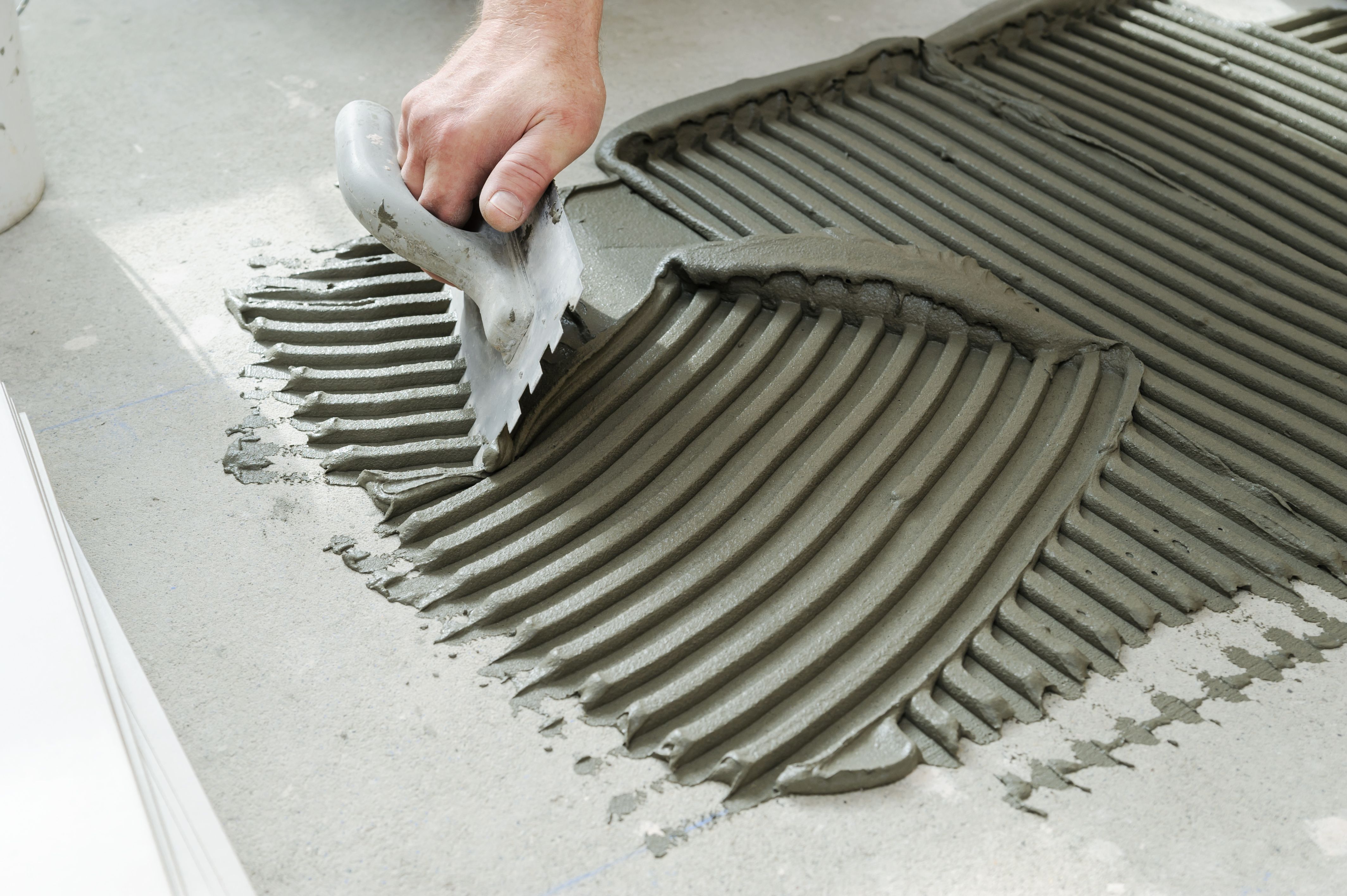 Käsi levittää laastia