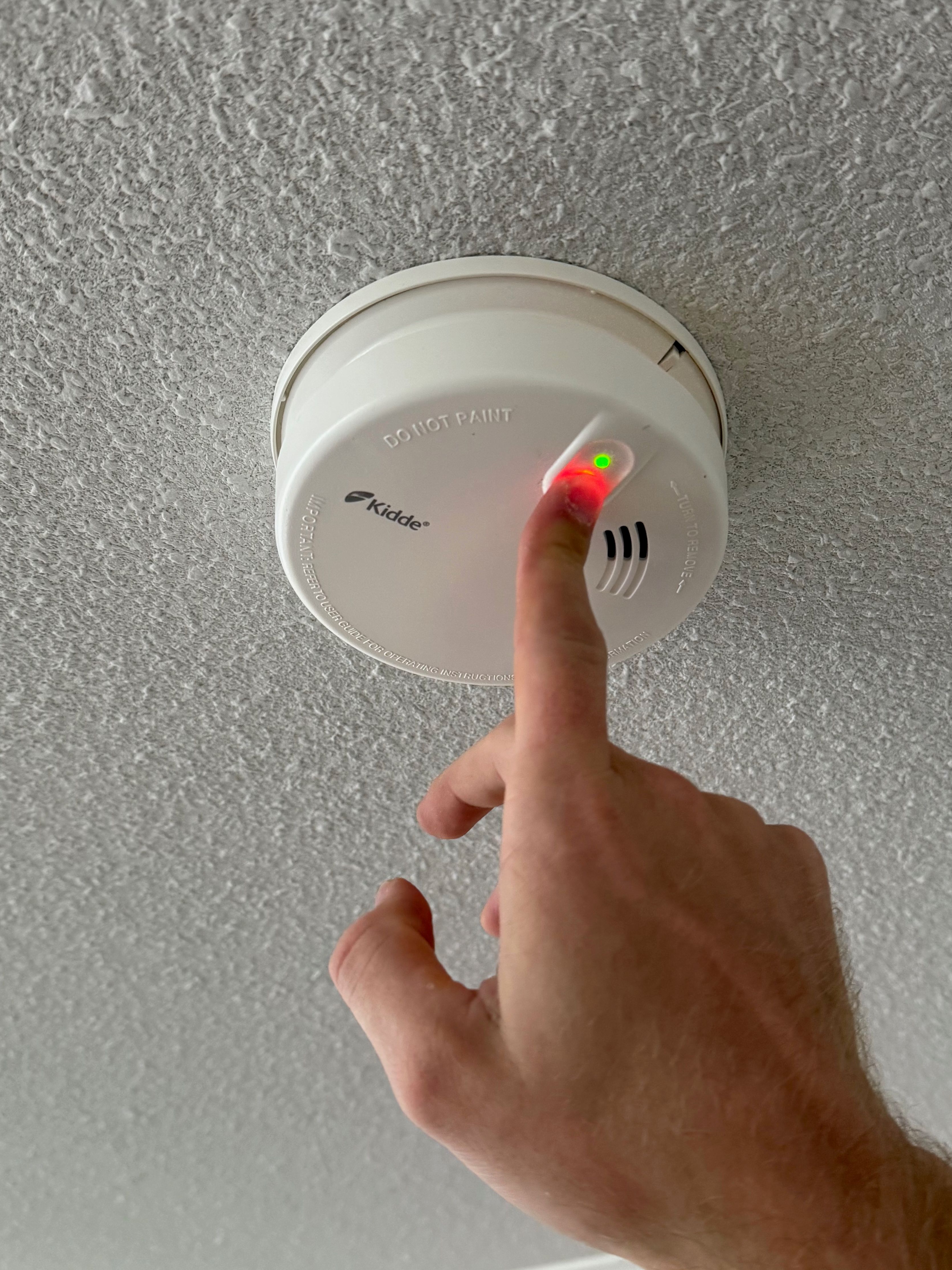 Palovaroittimen testinapin painaminen