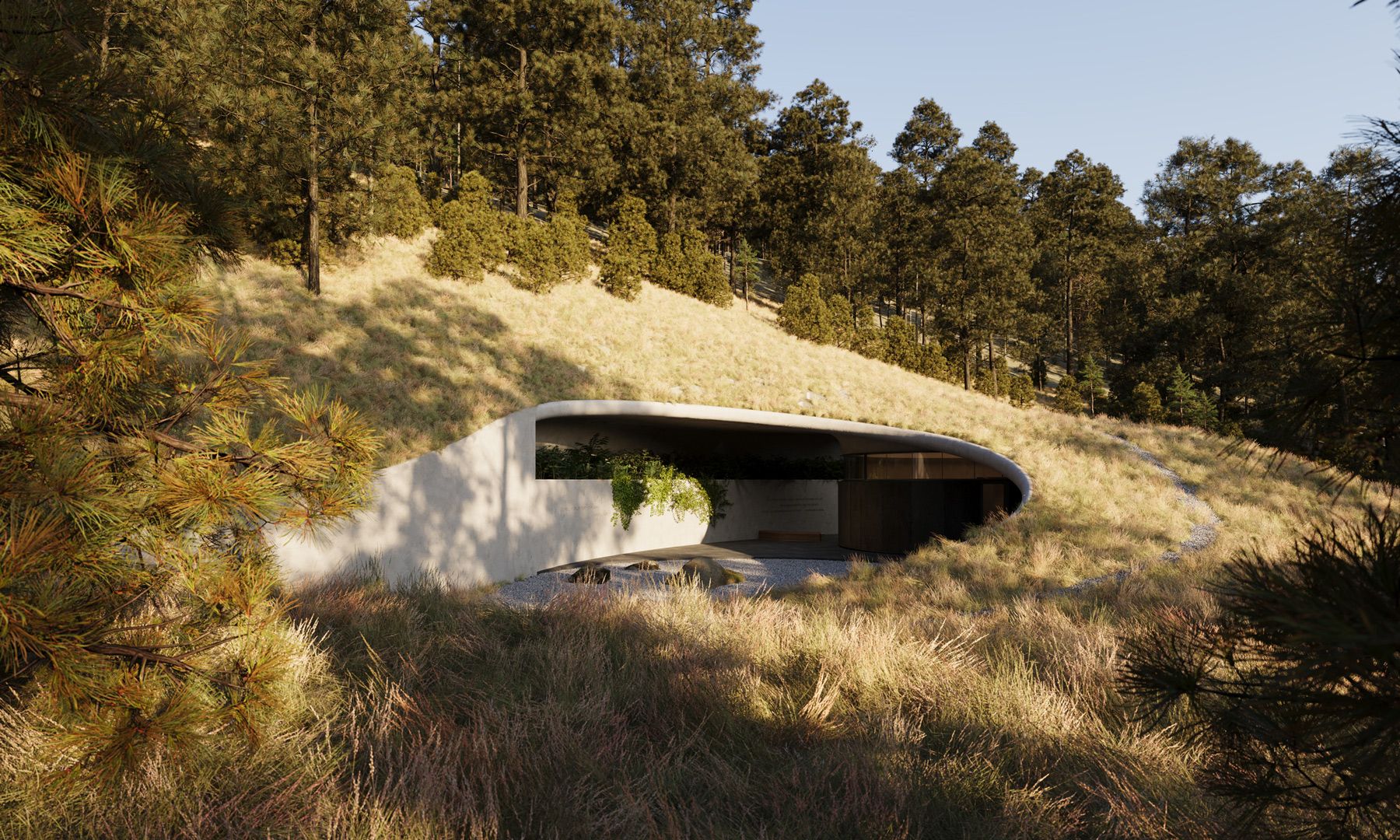 Modern earth-sheltered building with a curved concrete structure and a dark circular entrance, nestled into a grassy hillside with pine trees. A minimalist gravel courtyard with large rocks and wild grasses is in the foreground.