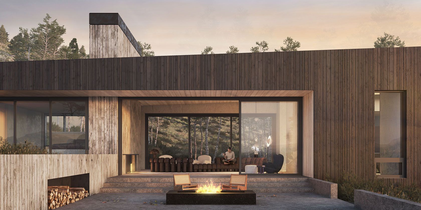 Contemporary woodland home featuring dark vertical wood siding, board-formed concrete, and expansive glass sliding doors. An outdoor living area with a lit fire pit and two modern chairs sits on a stone patio. Inside, a person relaxes in a cozy living room, visible through the windows, with a backdrop of lush trees under a soft, warm evening sky. Stacked firewood is stored below the concrete facade.