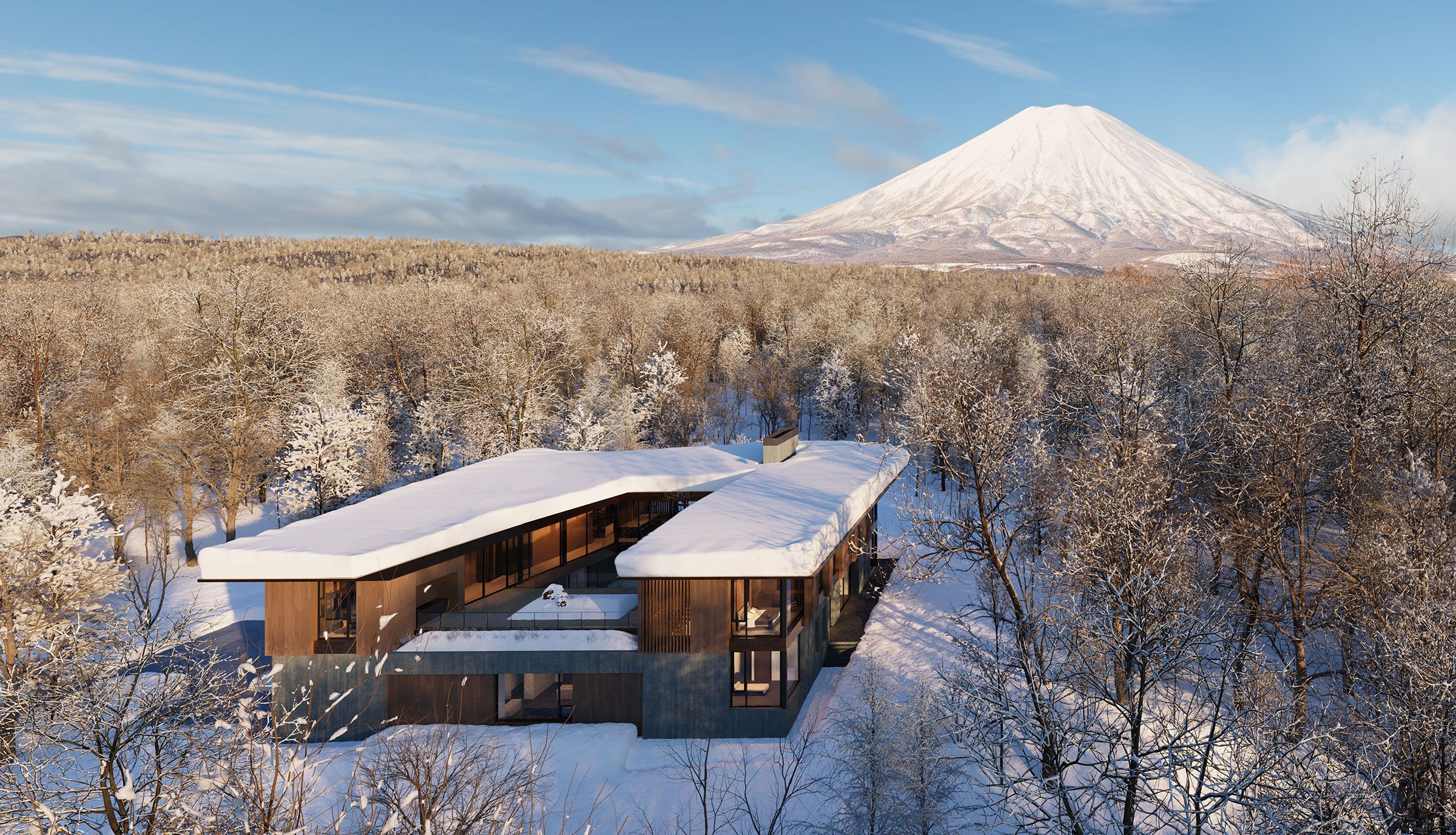 Aerial view of a modern snow-covered villa surrounded by a snowy forest with Mount Yoeti in the background.