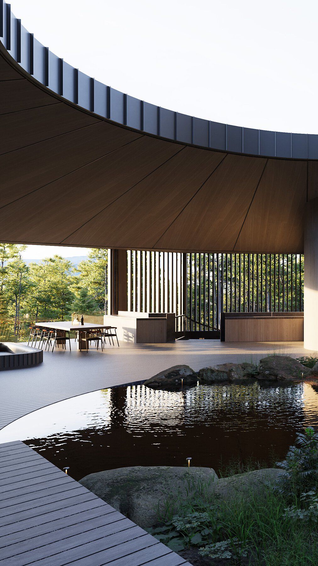 A modern open-air pavilion with a curved wood ceiling and an outdoor dining area, overlooking a lush forest through slatted screens. A natural pond with rocks and a wooden deck is in the foreground.