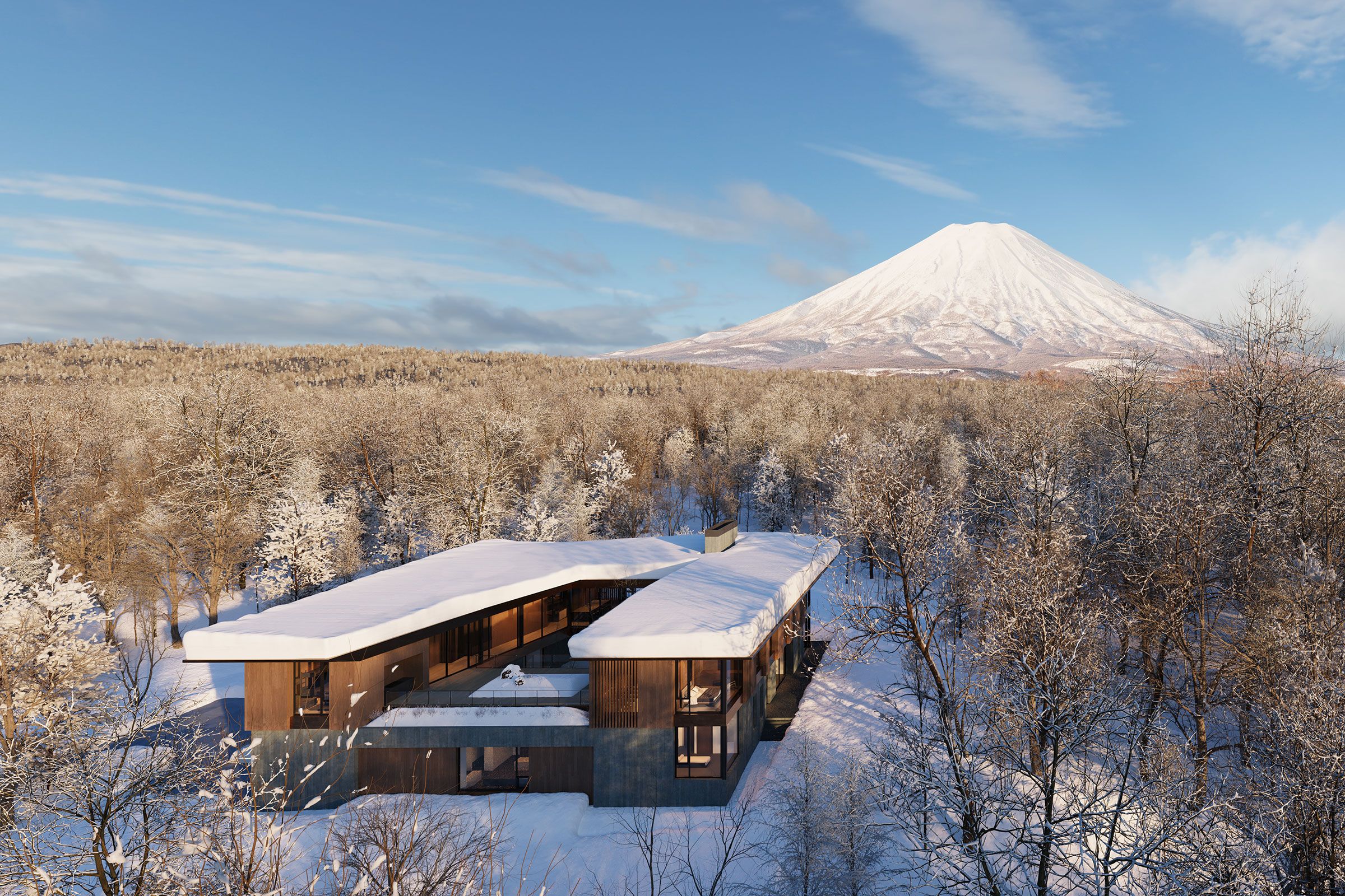 Aerial view of a modern snow-covered villa surrounded by a snowy forest with Mount Yoeti in the background.