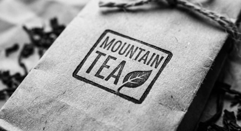 Hand-carved seal stamp pressed onto kraft paper tea packaging