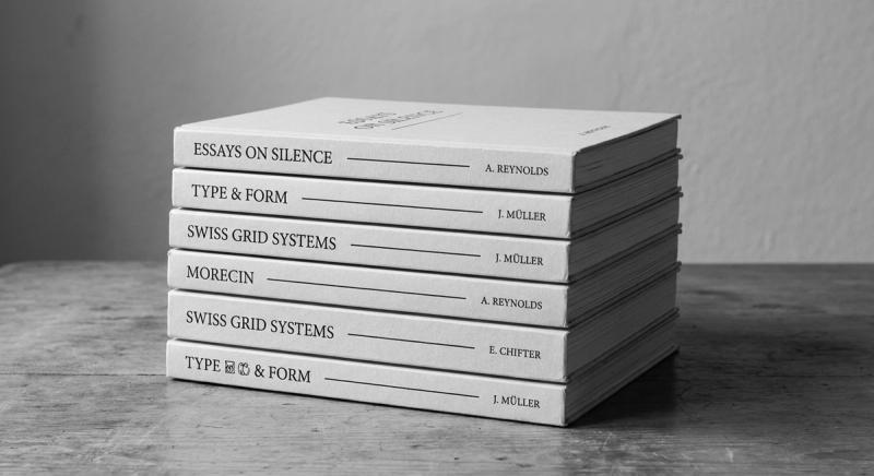Stack of minimalist typography-only book covers in black serif on warm white paper