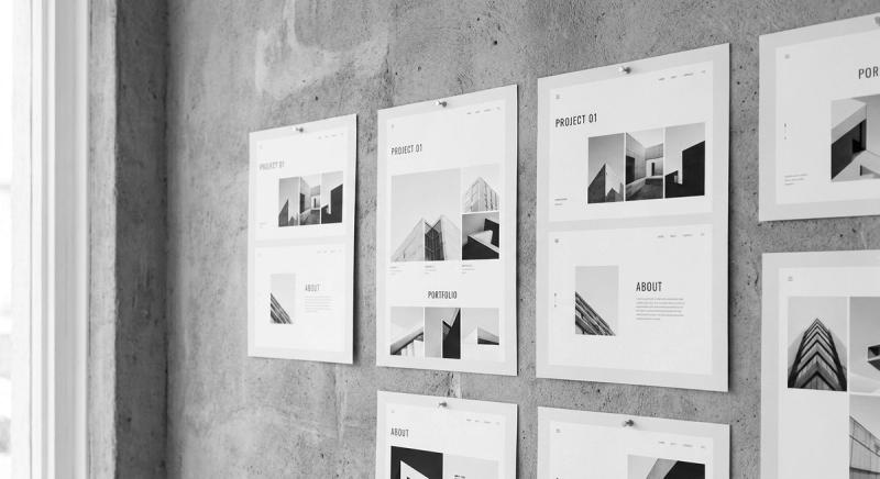 Website layouts printed on paper and pinned to a concrete wall