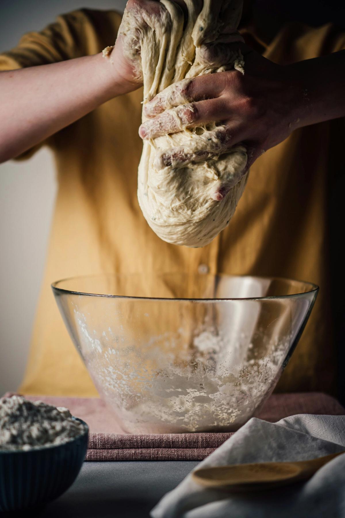 Someone mid making sourdough, pulling the dough