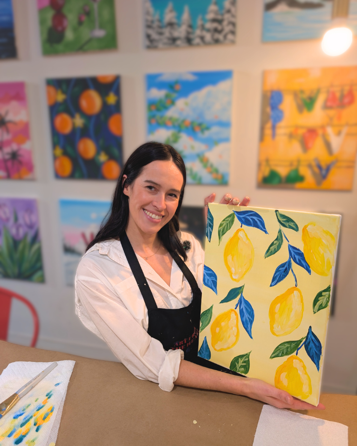 Maria, art from the heart's owner, holds up her completed painting