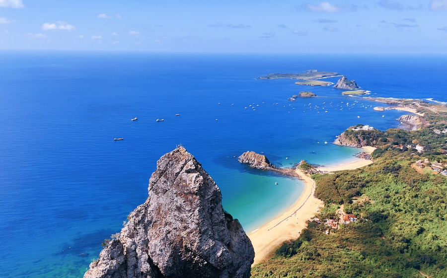 Foto aérea do Mar de Dentro, com a Praia da Conceição, a Praia do Meio, a Praia do Cachorro, o Forte dos Remédios, o Porto e as ilhas secundárias de Fernando de Noronha