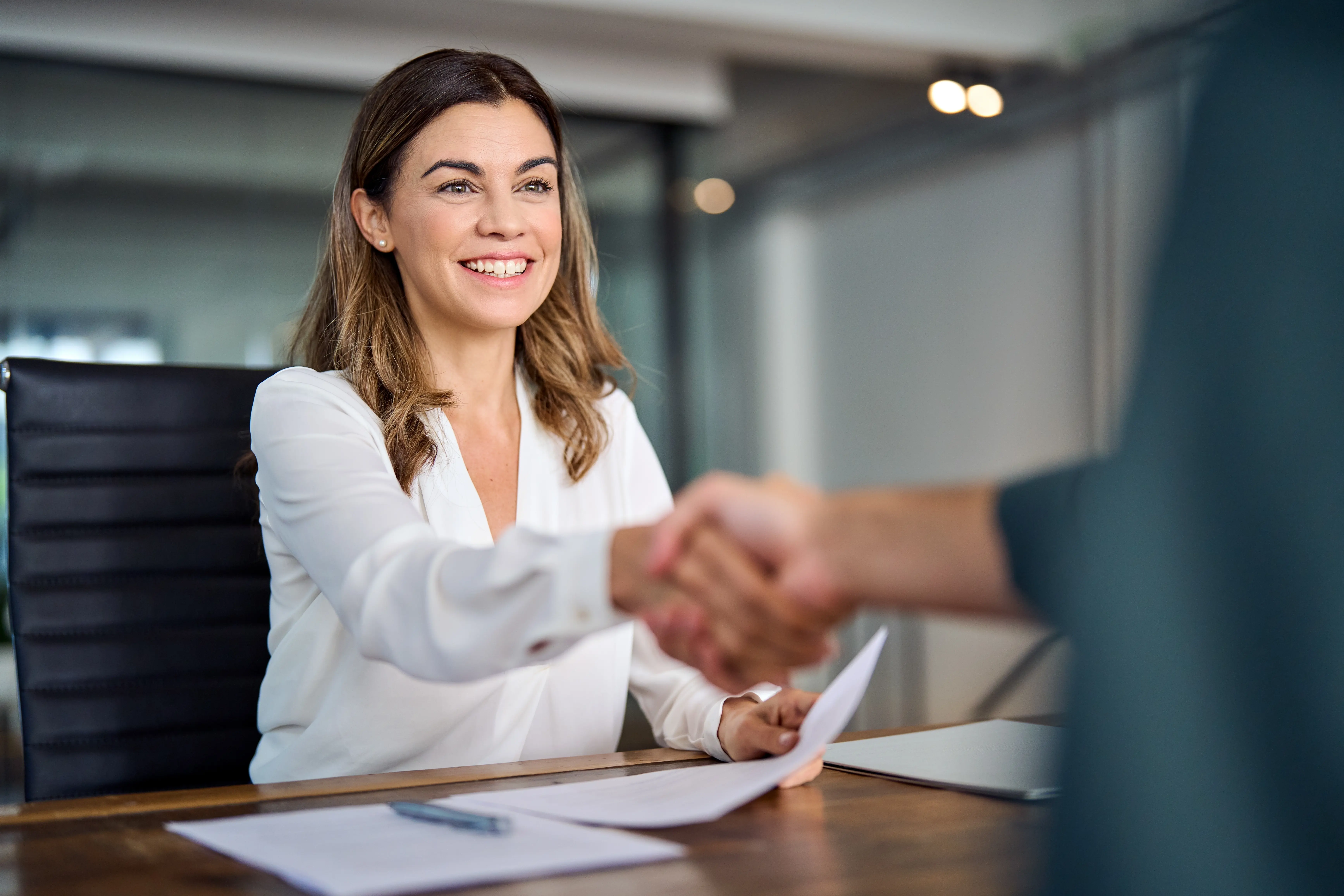 A woman shaking hands with another woman.