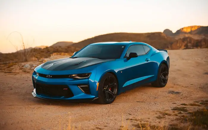 A blue sports car parked on an open desert road