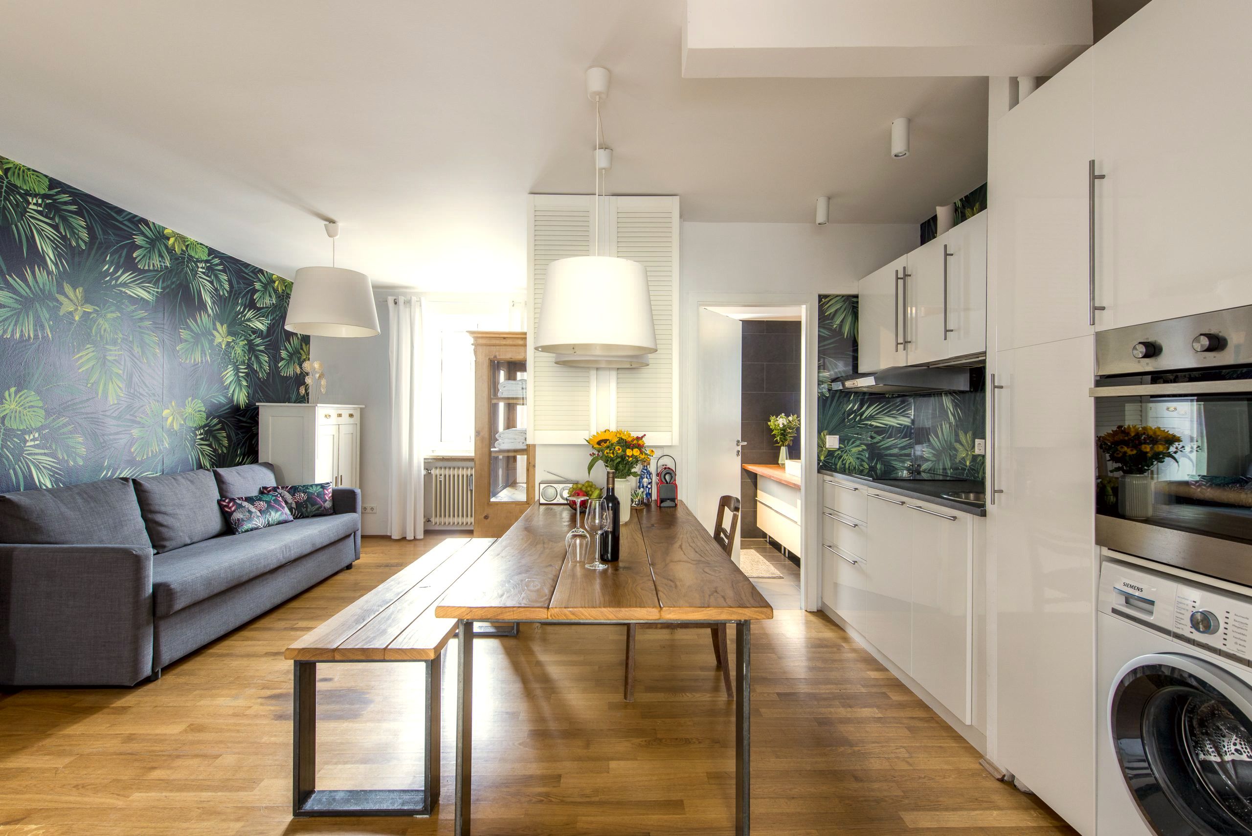 Wohnküche des Mozart Apartments mit Esstisch, Sofa und Küchenzeile