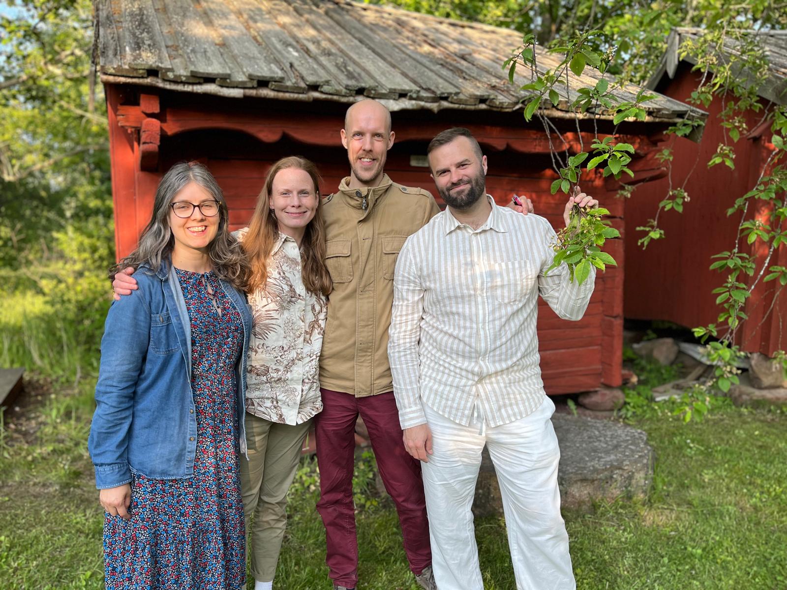 Lisa Jansson, Elin Johansson, Håkan Eriksson, och Robert Carlsson framför en gammaldags träbod i faluröd färg.
