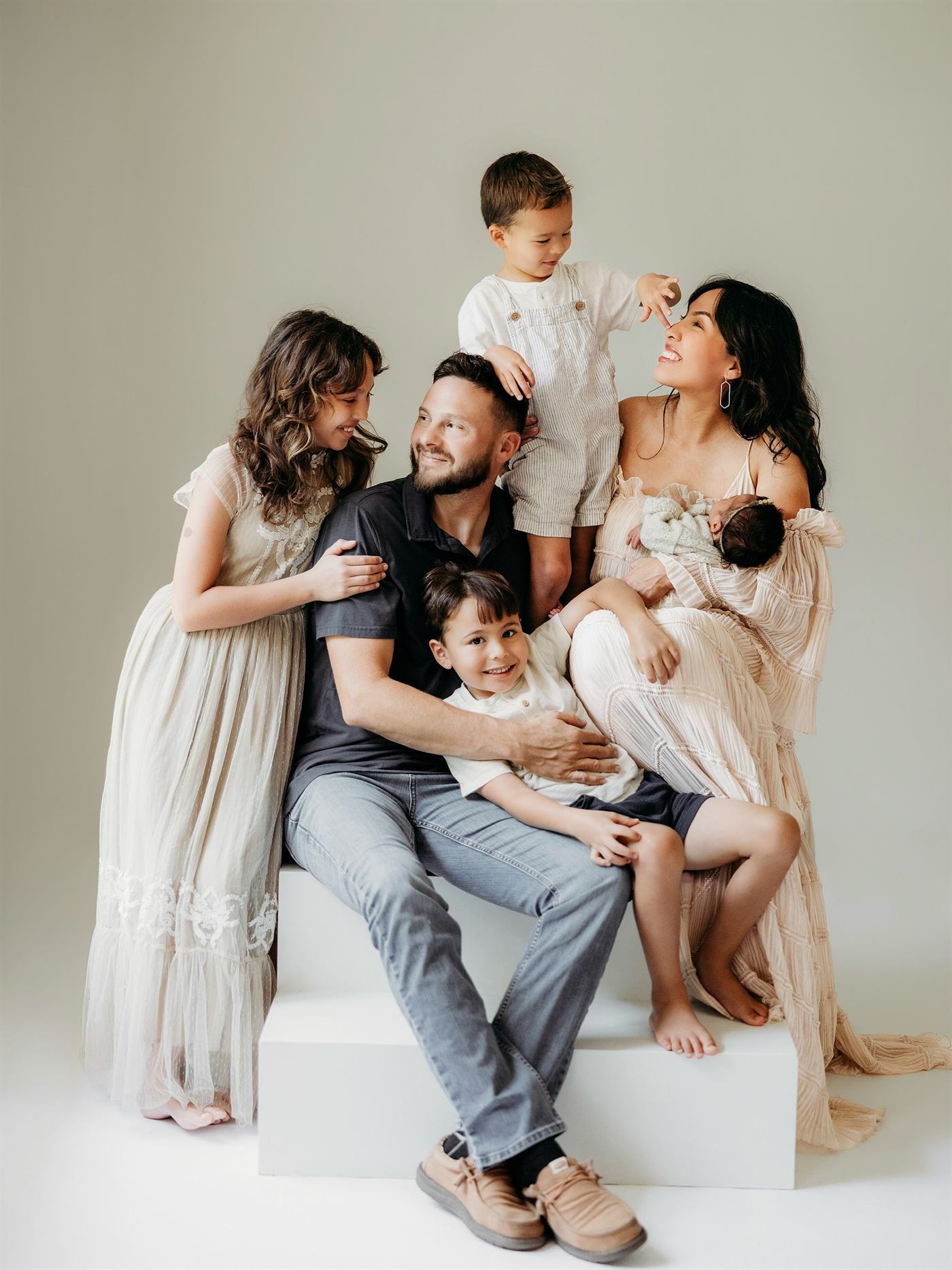 Parents and four children sharing a laugh in a bright studio