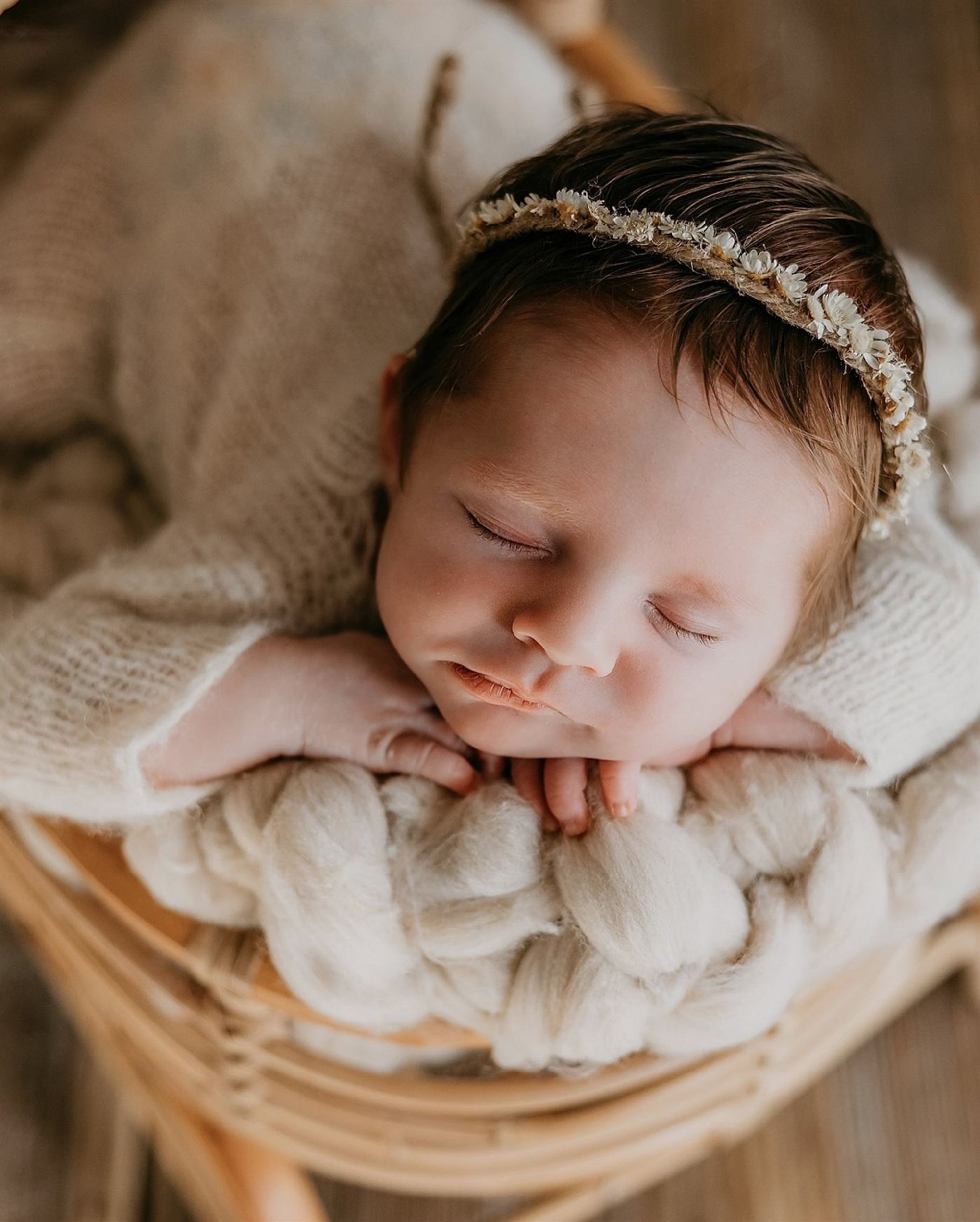 Close detail of a sleeping newborn resting on tiny folded hands