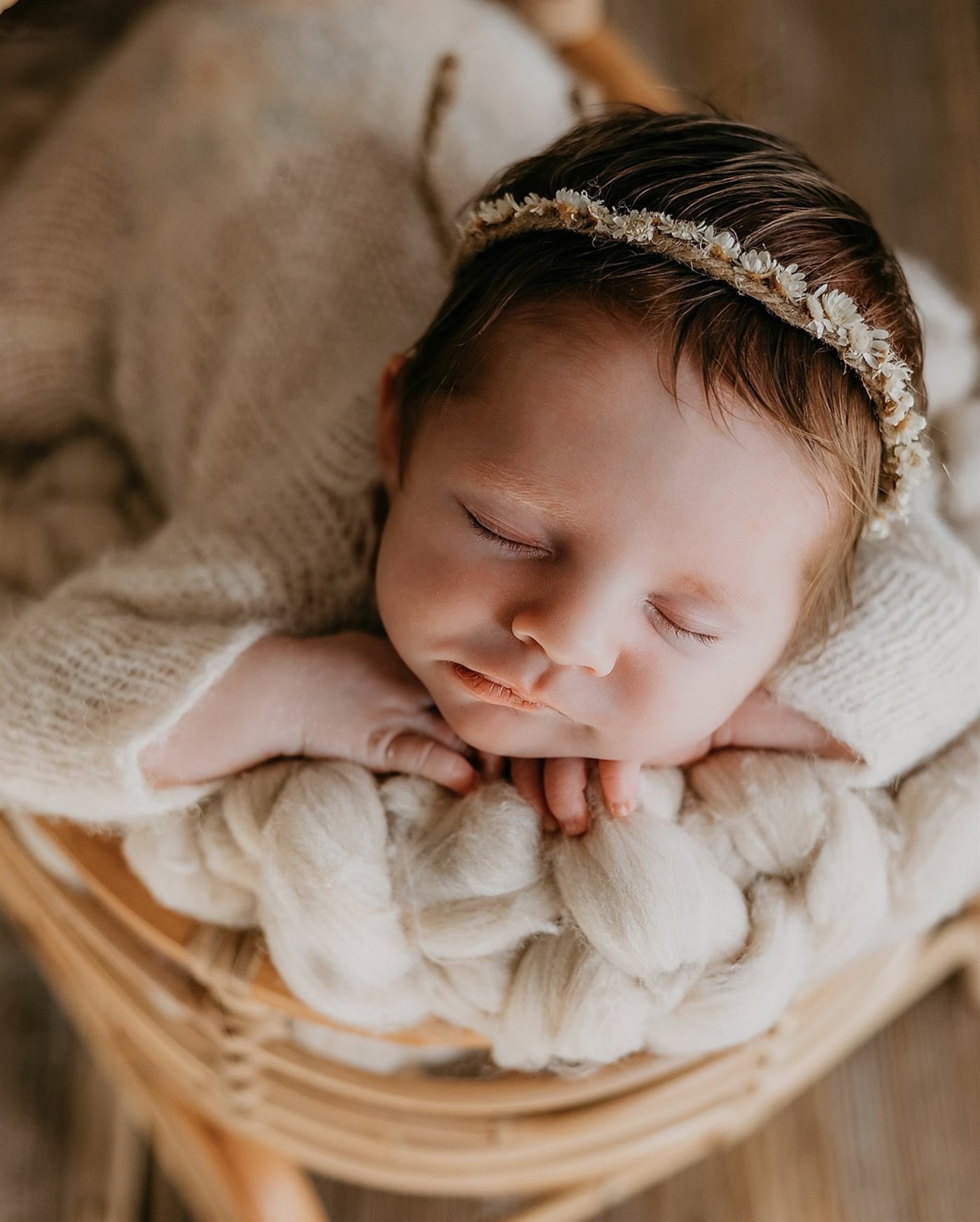 Close detail of a sleeping newborn resting on tiny folded hands