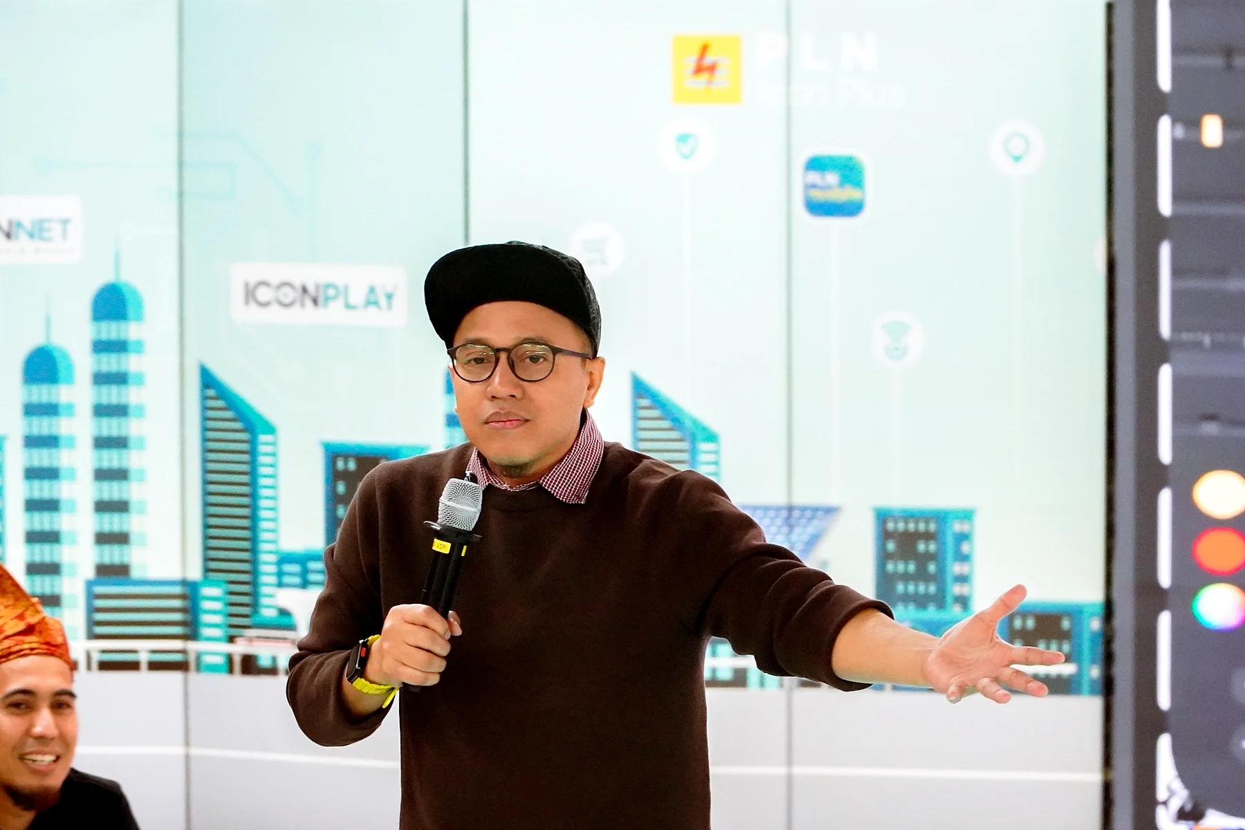 Coach Yoso Lukito berbicara sambil memegang mikrofon dan merentangkan tangan di depan peserta