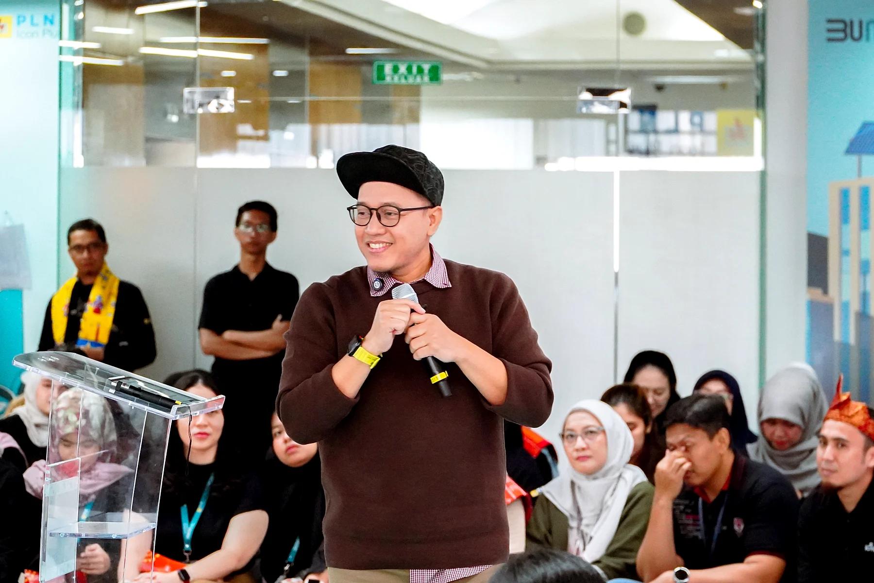 Coach Yoso Lukito tersenyum sambil memegang mikrofon saat berbicara di depan peserta acara