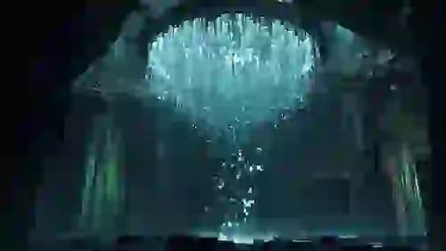 A hyper-realistic cinematic shot of a glowing blue holographic financial matrix sorting and filtering thousands of digital tokens, dropping the weak into a dark abyss, 8k resolution.