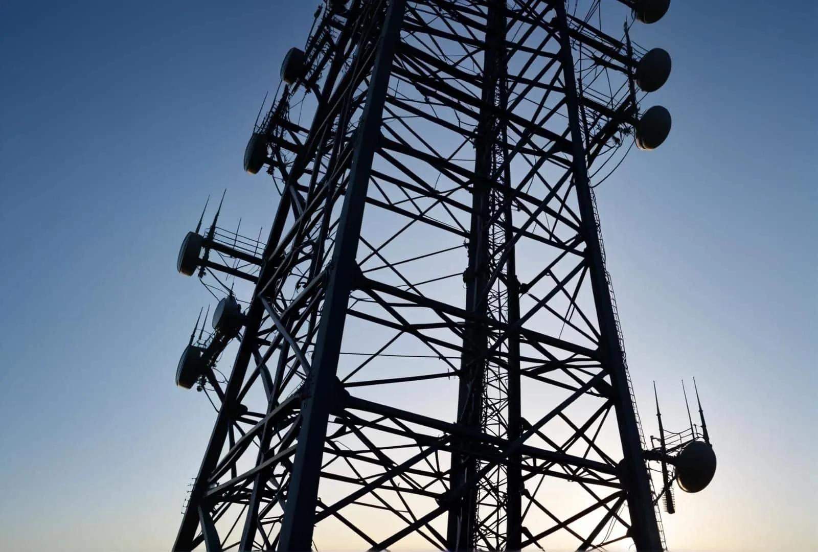 Cellular tower with antennas against a dusk sky