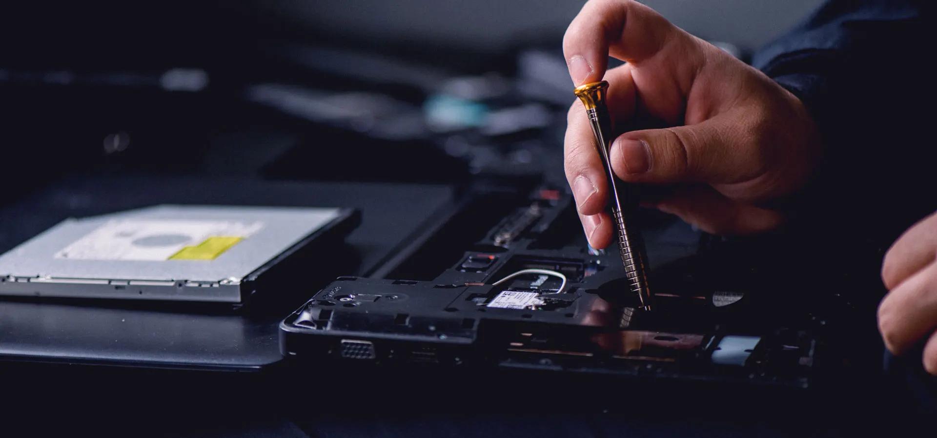 Technician repairing a hard drive with a precision tool