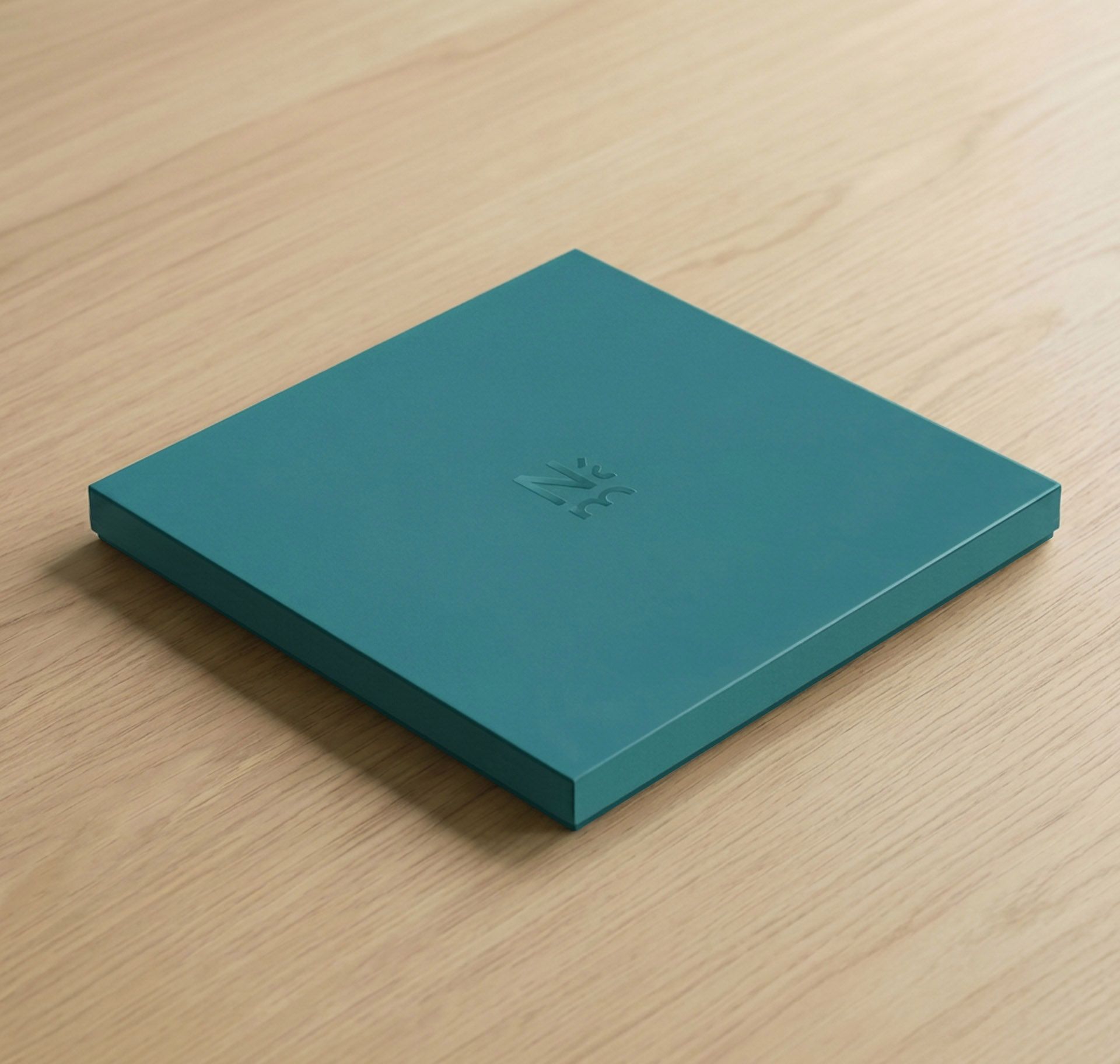 The Nasjonalmuseet gift box in fjord blue — a silk-finish square box with embossed museum mark, on warm oak