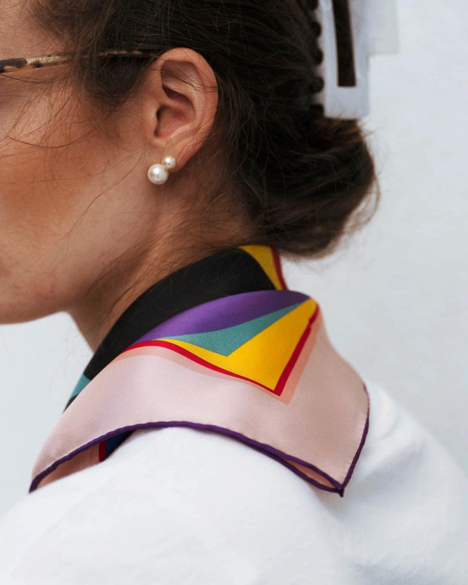 The Gundersen scarf worn loosely around the collar, showing the corner colours