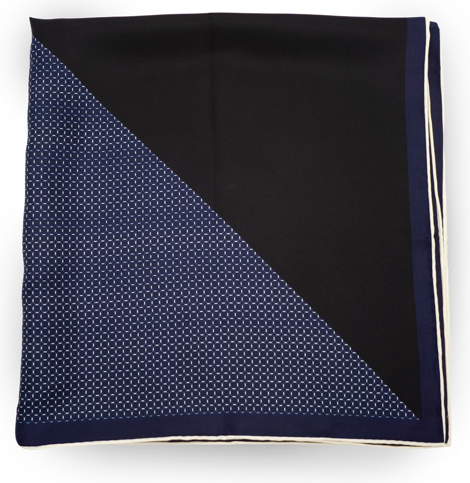 The Signature Bandana folded to show both faces: solid black and the navy dot-pattern