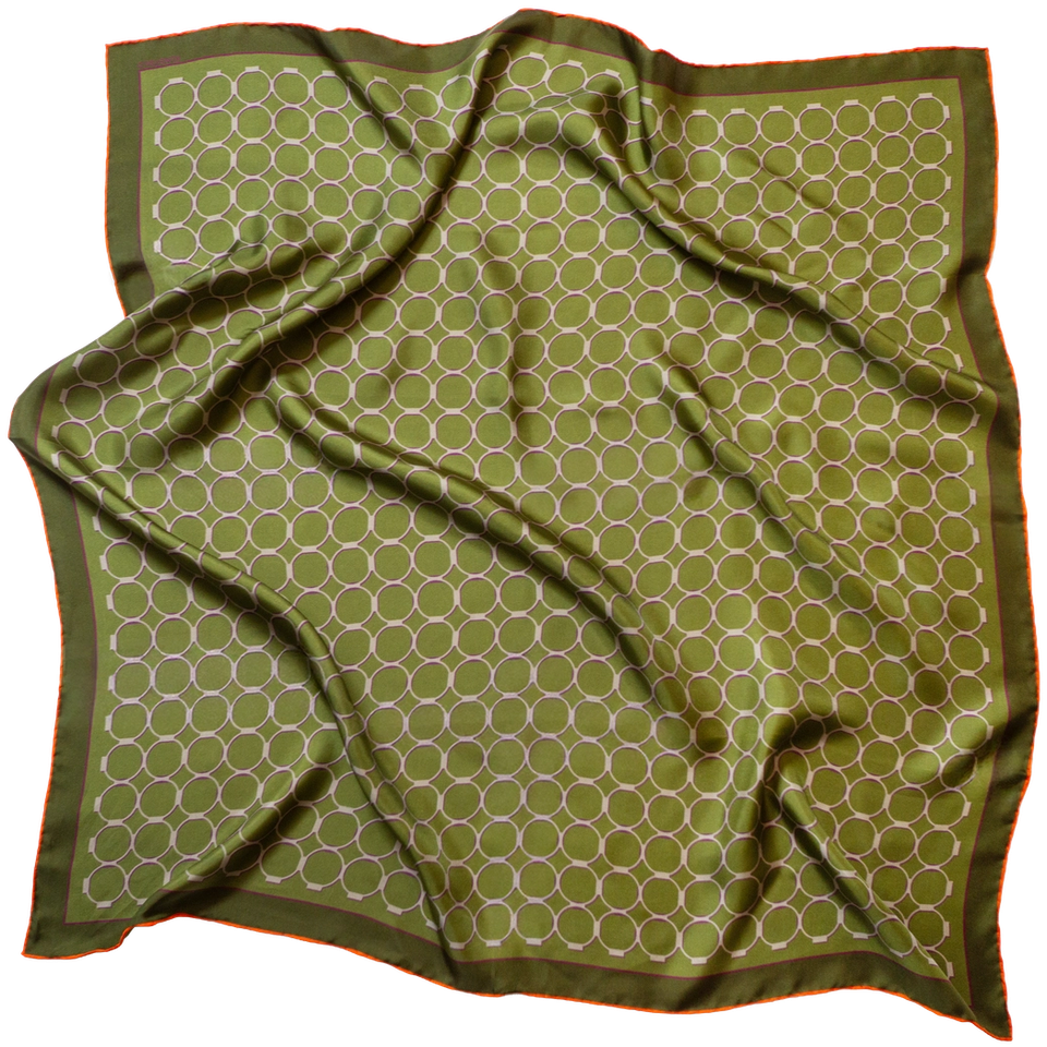 The Kunstsilo Signature silk scarf in olive green — the silo’s ring geometry across the ground, with an orange hand-rolled edge