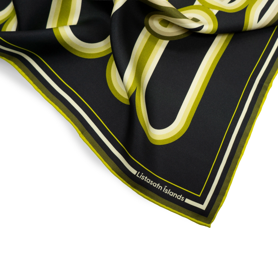 Corner detail of the Signature Lines scarf — chartreuse ribbon forms and the "Listasafn Íslands" label on the rolled edge