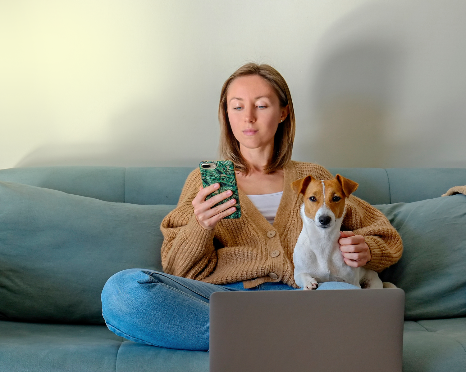 photograph of a woman on her phone and drinking coffee from home