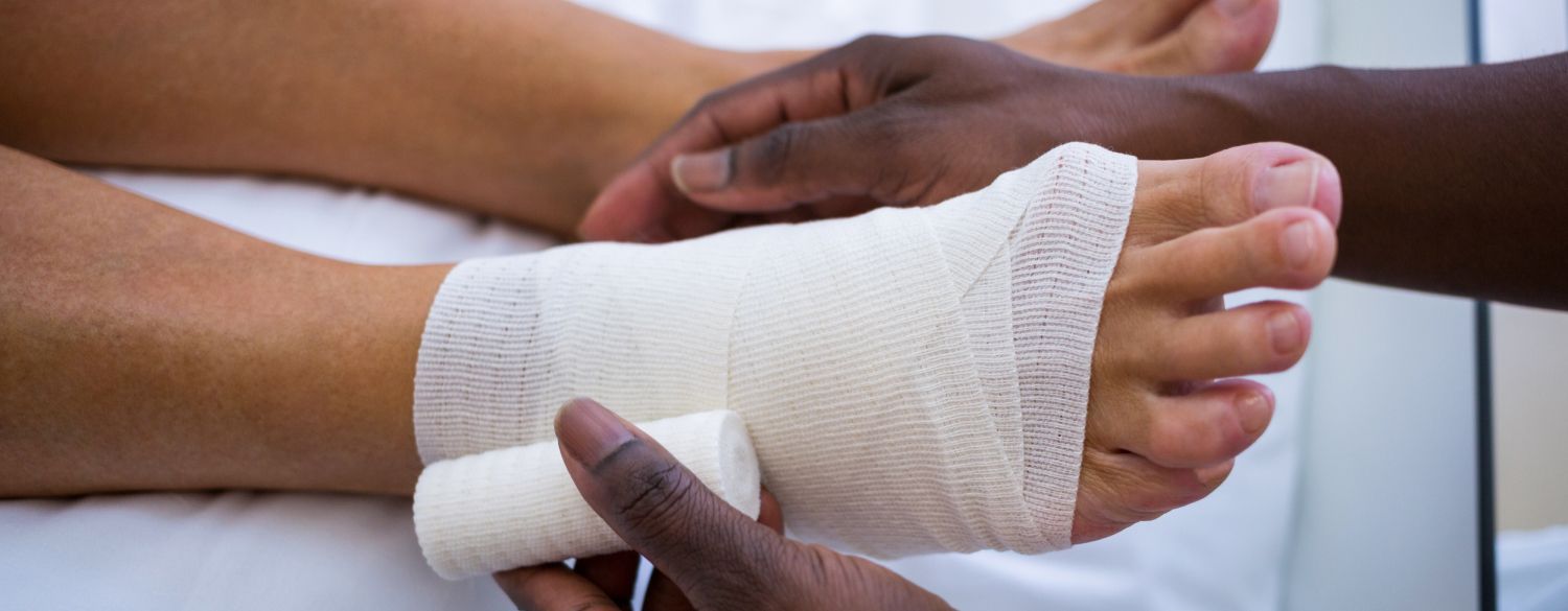 medical professional wrapping a foot wound 