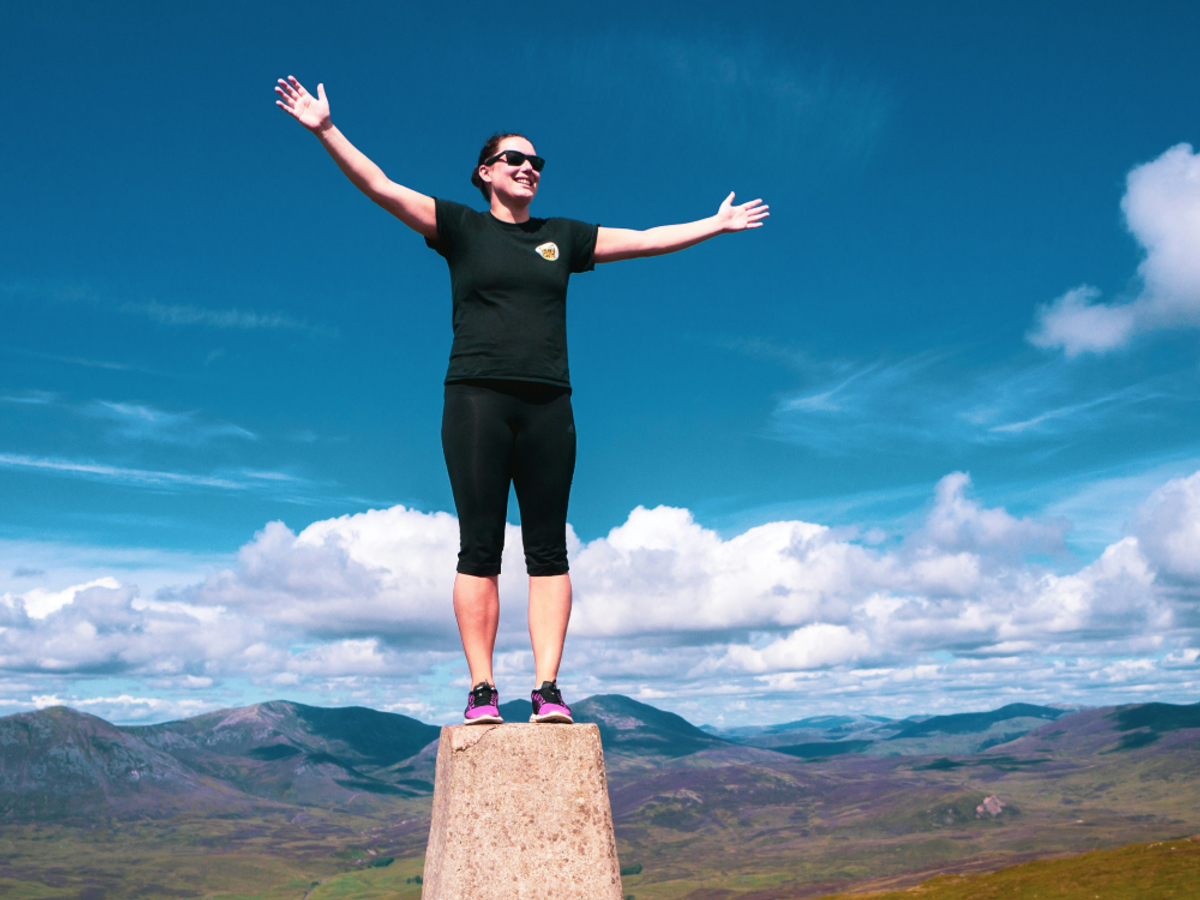 Female celebrating at the top of a mountain 