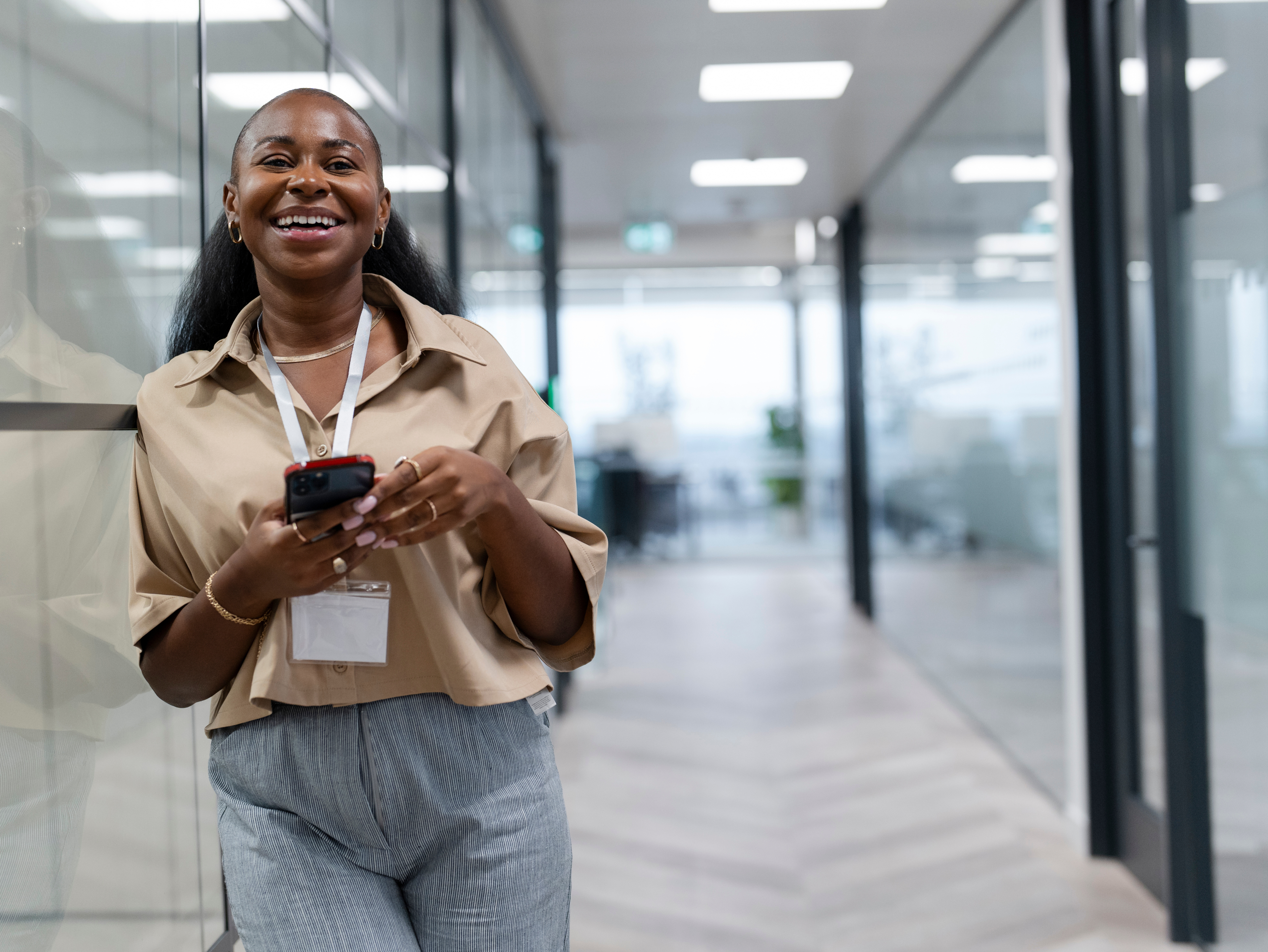 photo of an employee smiling while holding her phone in an office