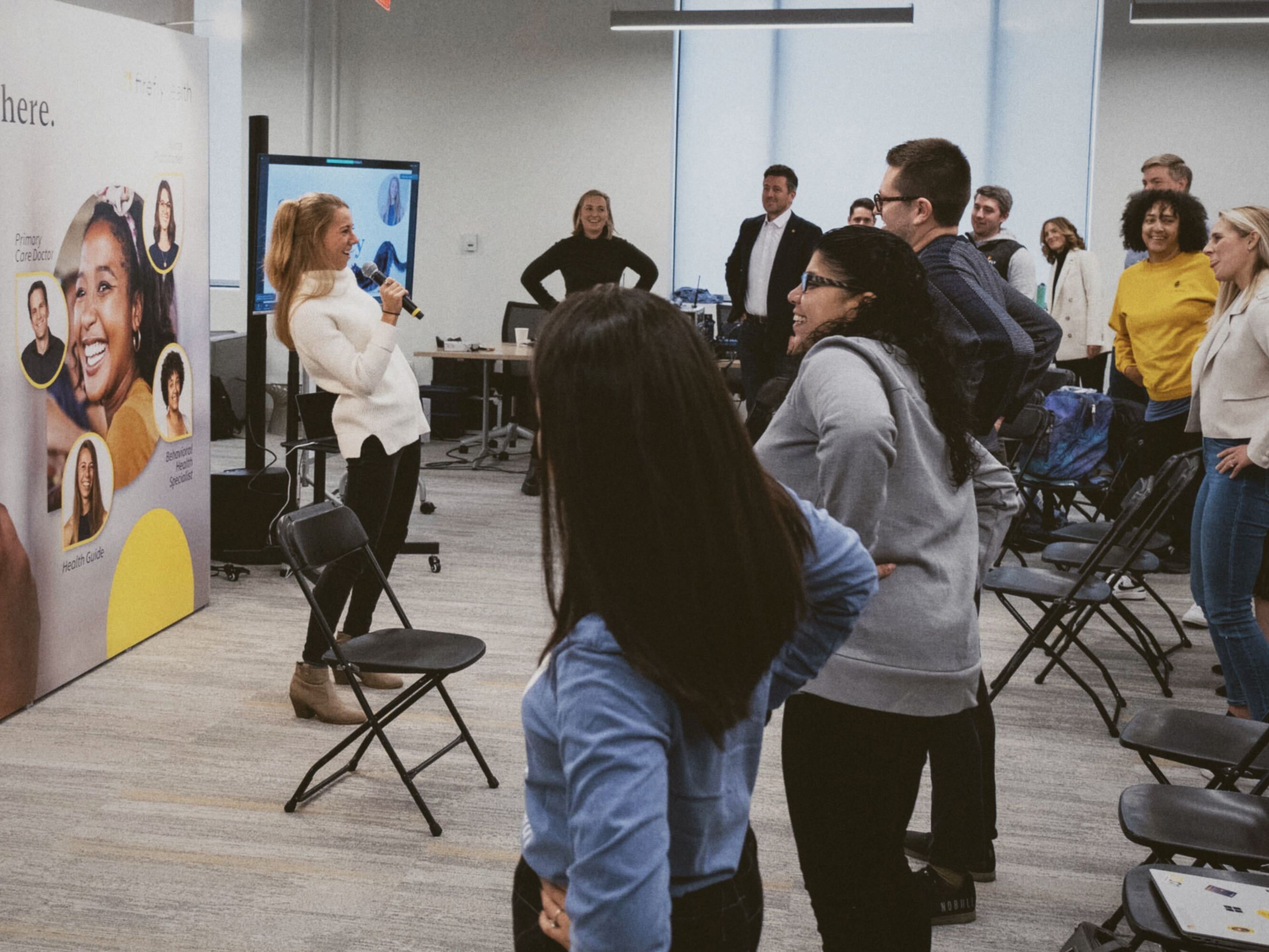 Firefly employees in the office standing up stretching together 