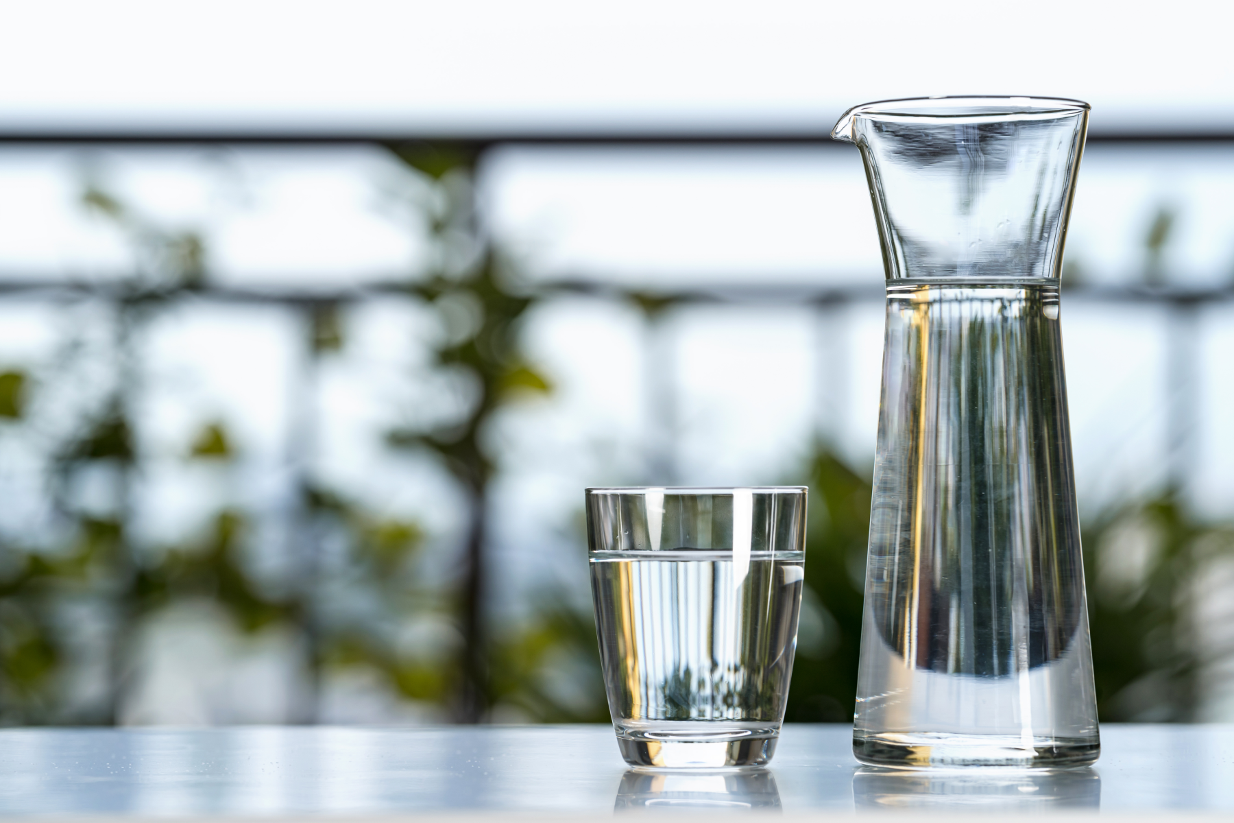 A glass and pitcher filled with water