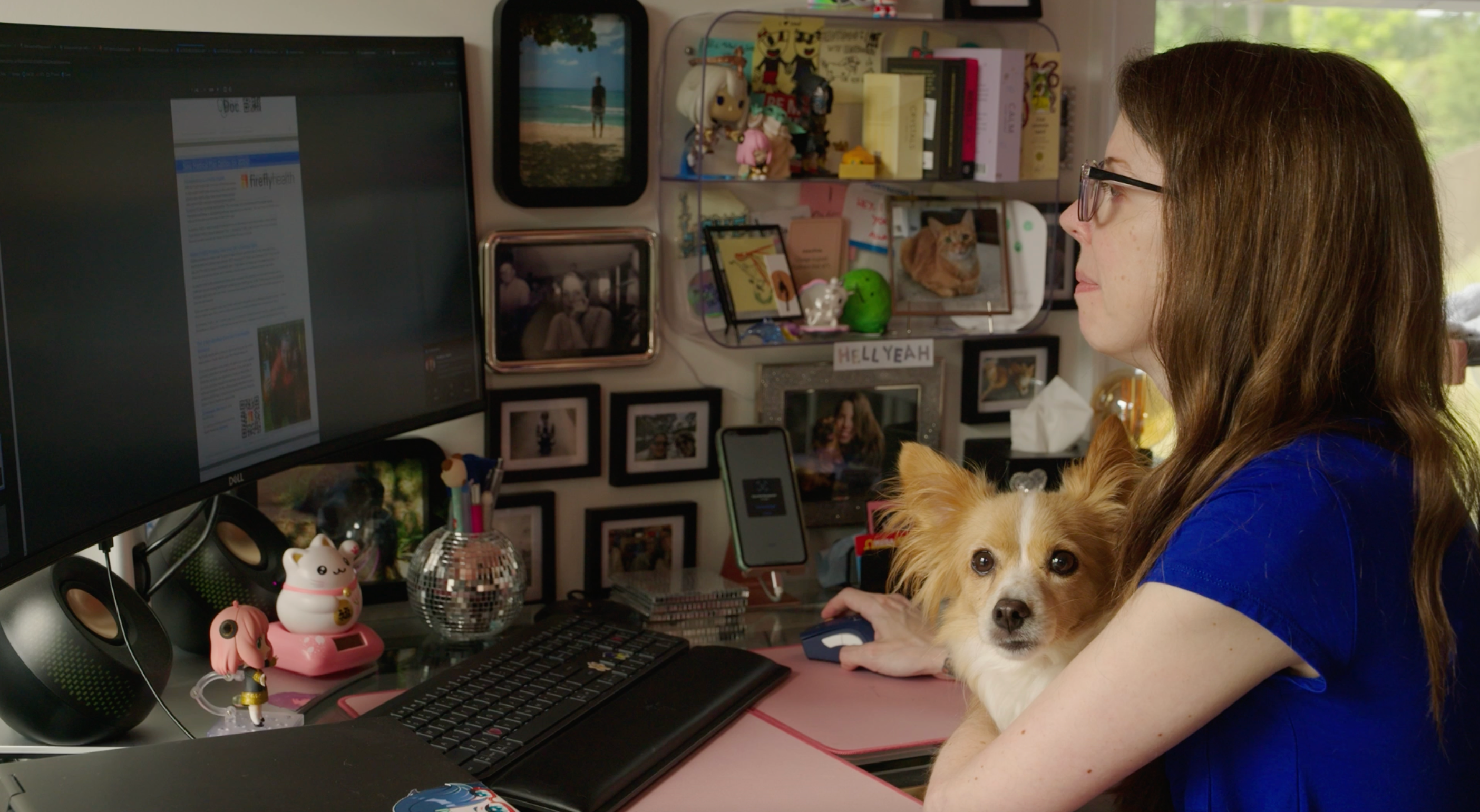 Regina in her office looking at her computer with a dog in her lap