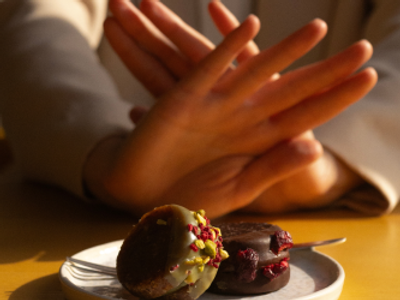 female hands blocking dessert signling a good health choice 
