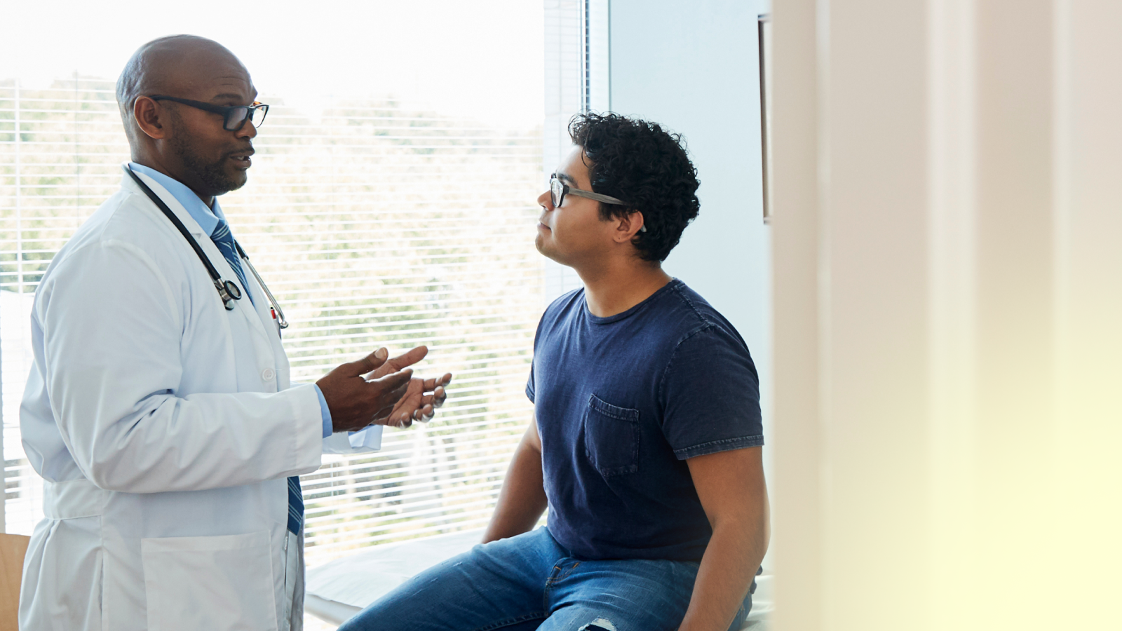 Man sitting in doctor office, doctor speaking to him