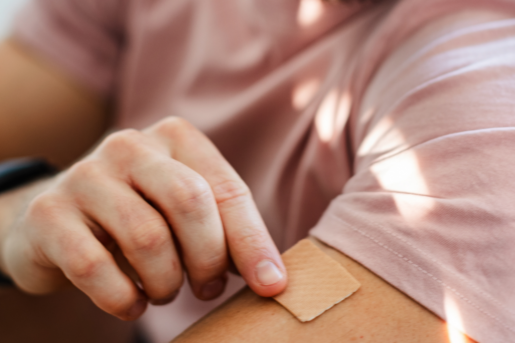Male placing a nicotine patch on his arm
