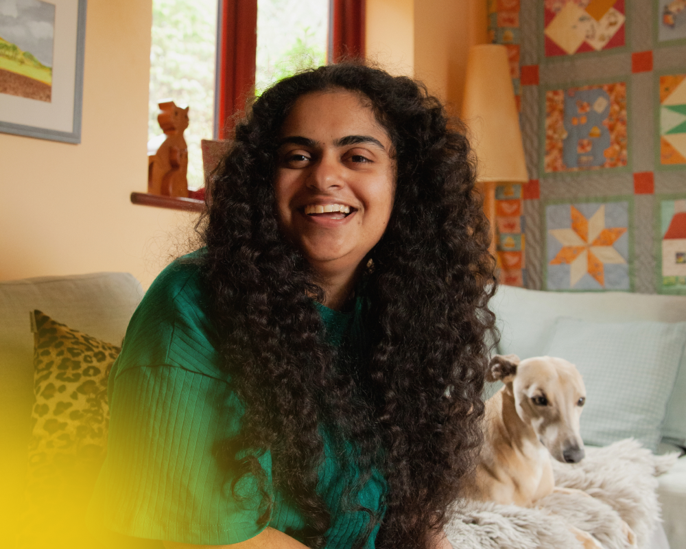 photograph of a woman on her phone at home with her dog