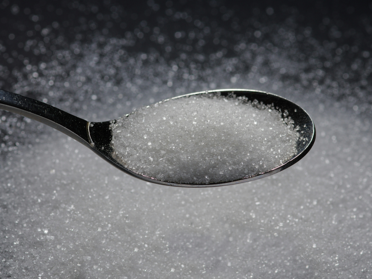spoonful overflowing with white sugar